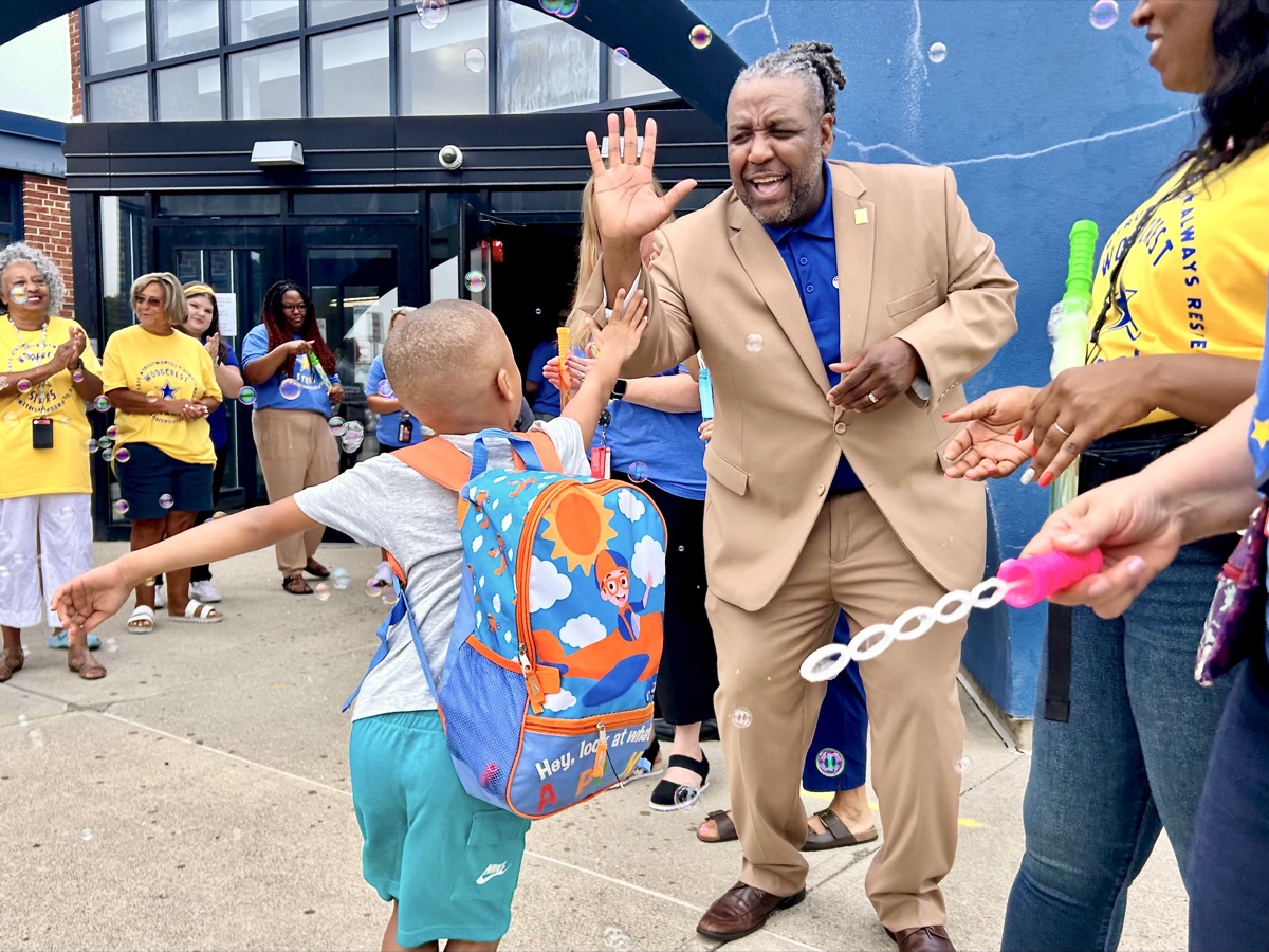 Dr. Grubbs high-fiving a student on the first day of school